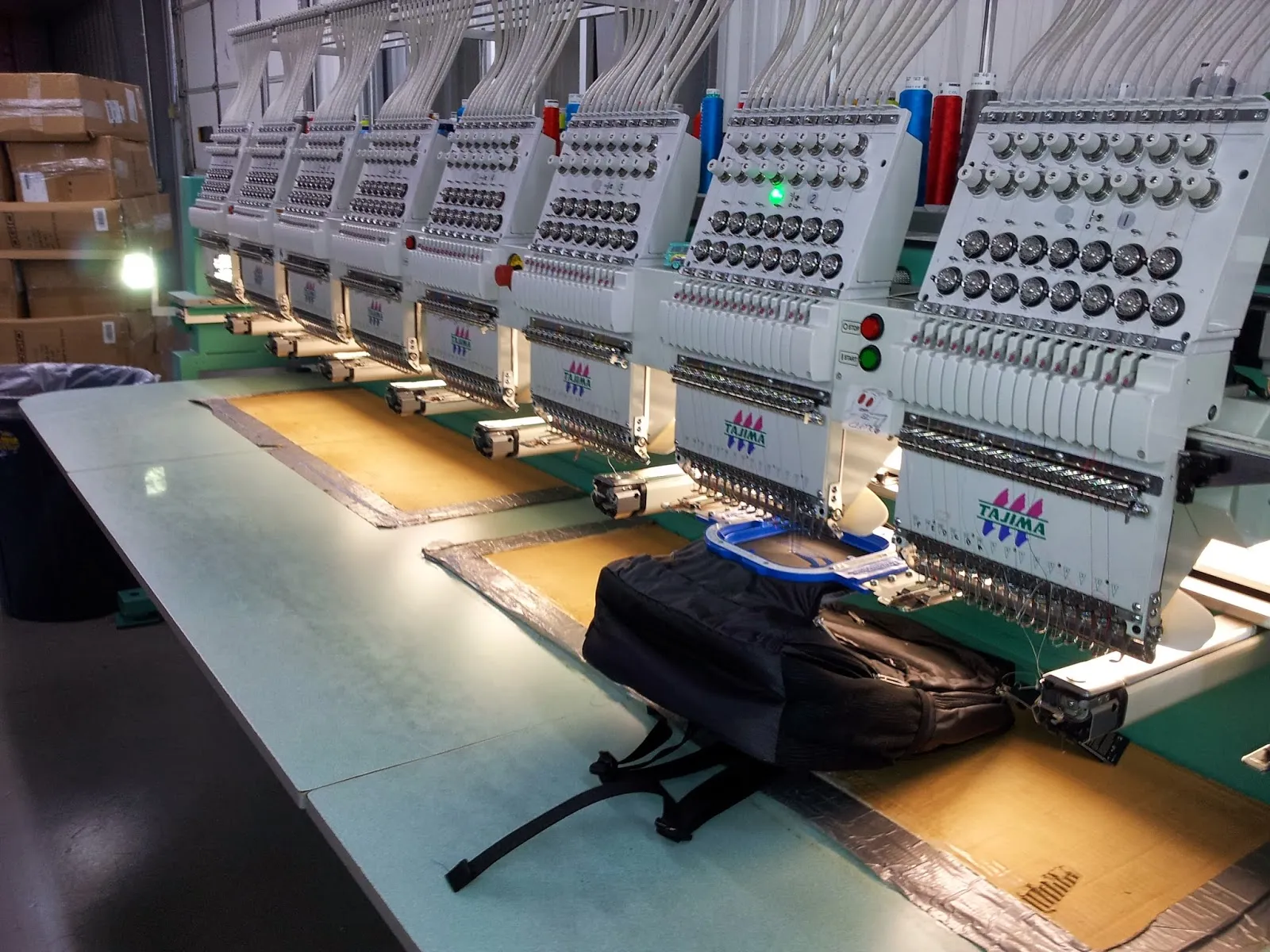 Operario trabajando en una bordadora industrial en la planta de VVF